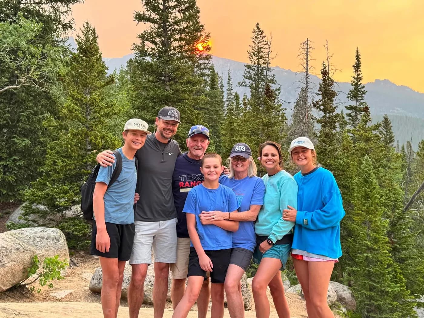 The Goswick family together on a mountain trail at sunset